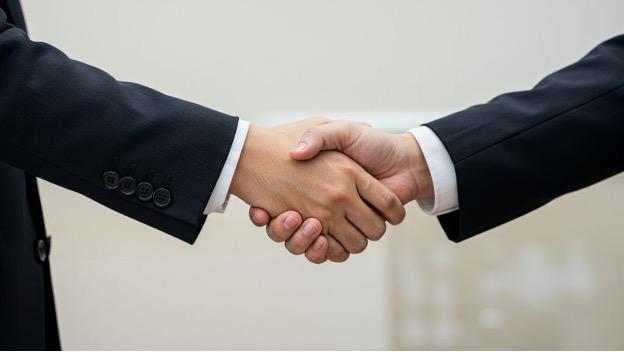 産業医と人事労務担当者が握手している、円満な契約締結をイメージした写真.jpg